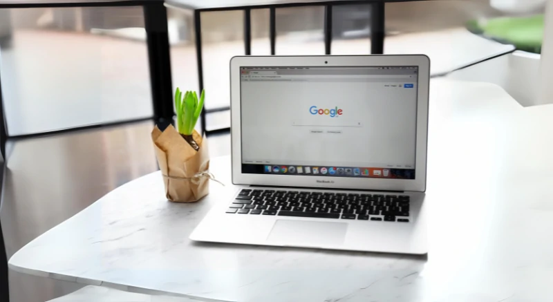 Laptop opens Google search engine page on browser.